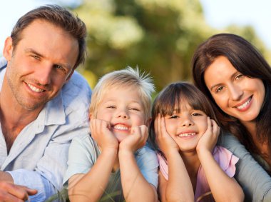 Family lying down in the park clipart