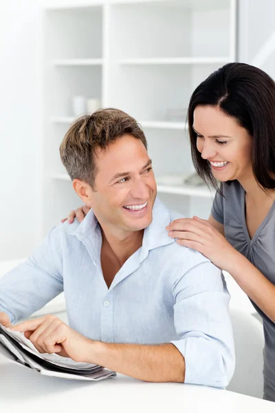 Happy man showing something on the newspaper to his girlfriend — Stock Photo, Image