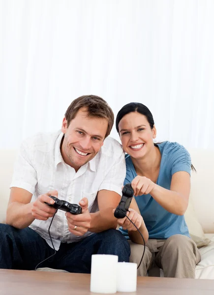 Emocionada pareja jugando videojuegos juntos en el sofá —  Fotos de Stock