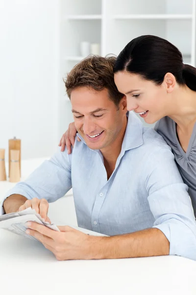 Lovely couple looking at something on the newspaper — Stock Photo, Image