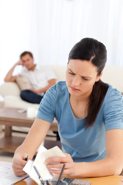 Mulher irritada fazendo sua conta enquanto seu namorado esperando — Fotografia de Stock