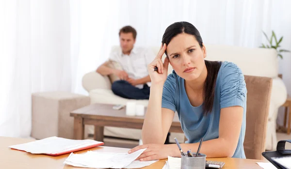 Worried woman doing her account while her boyfriend waiting in t — Stock Photo, Image