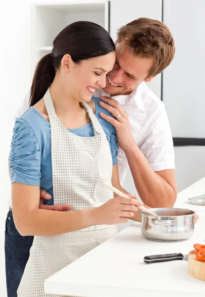 Pár nevetve, miközben készül a mártás, a konyhában — Stock Fotó