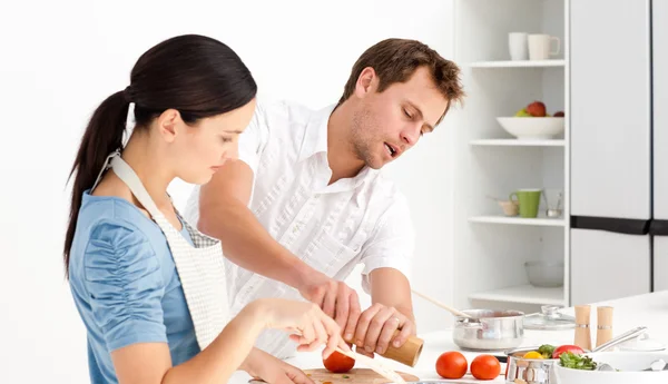 Man putting salt and pepper while his girlfriend stiring the sau — Stock Photo, Image