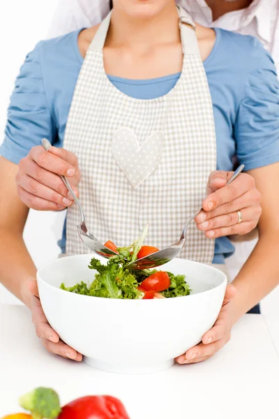 Close up de um casal misturando uma salada juntos na cozinha — Fotografia de Stock