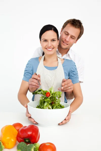 Glückliche Frau mixt mit ihrem Freund in der Küche einen Salat — Stockfoto