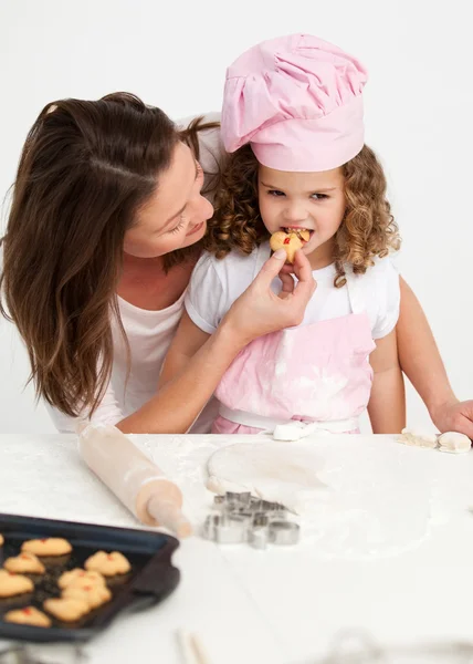 Bambina che assaggia un biscotto con sua madre — Foto Stock
