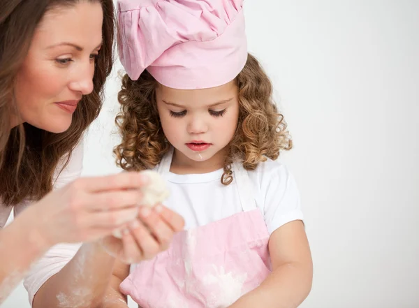 Glad mother and her daughter making biscuits together — Stock Photo, Image