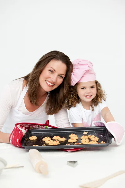 Adorável mãe e filha mostrando um prato com biscoitos — Fotografia de Stock