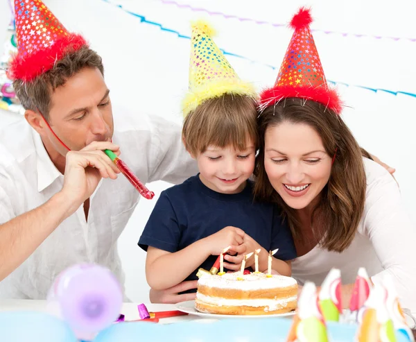 Gelukkige familie blazen kaarsen samen voor een verjaardag — Stockfoto
