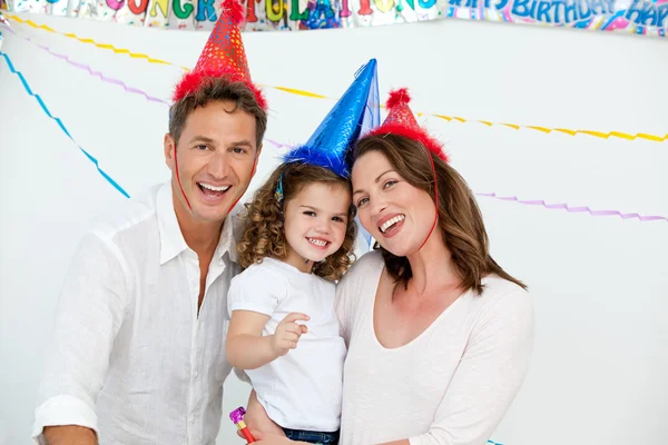 Porträtt av söt liten flicka med sina föräldrar under en födelsedag — Stockfoto
