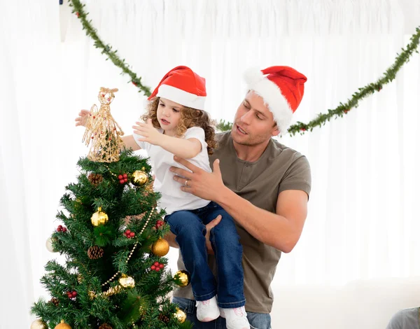 Χαριτωμένο κόρη διακοσμώντας το χριστουγεννιάτικο δέντρο με τον πατέρα του — Φωτογραφία Αρχείου