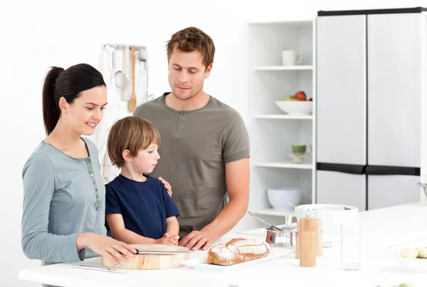 Família feliz comer pão na cozinha — Fotografia de Stock