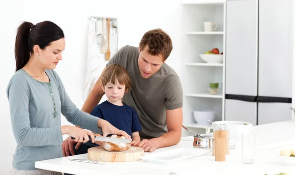Mooie vrouw snijden brood voor haar zoon advertentie man — Stockfoto