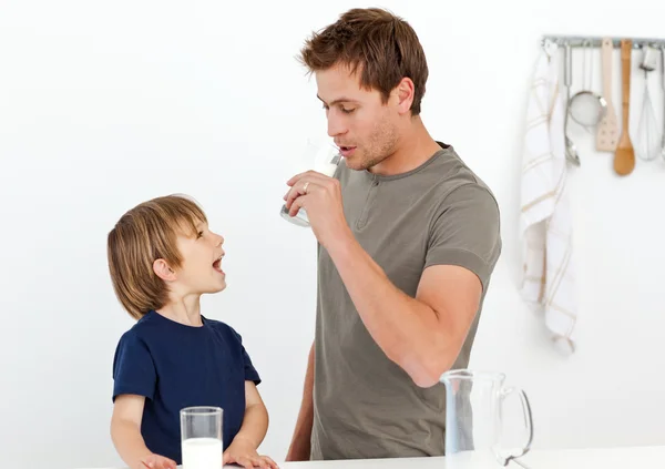 Feliz pai e filho bebendo leite juntos — Fotografia de Stock