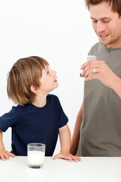 牛乳を飲む彼の父親を見ている小さな男の子 — ストック写真