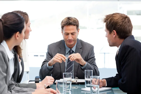 Ernstige manager bij een tabel met zijn team tijdens een vergadering — Stockfoto