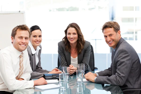 Retrato de uma mulher de negócios com sua equipe sentada a uma mesa — Fotografia de Stock