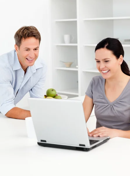 Lyckliga paret tittar på sin laptop och dricka kaffe — Stockfoto