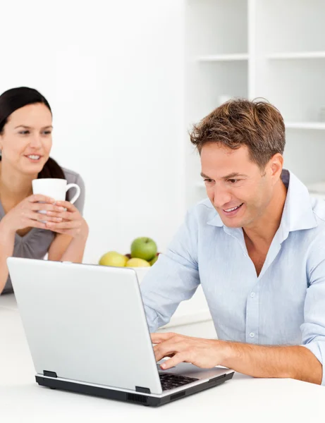 Schöne Frau trinkt Kaffee, während ihr Mann arbeitet — Stockfoto