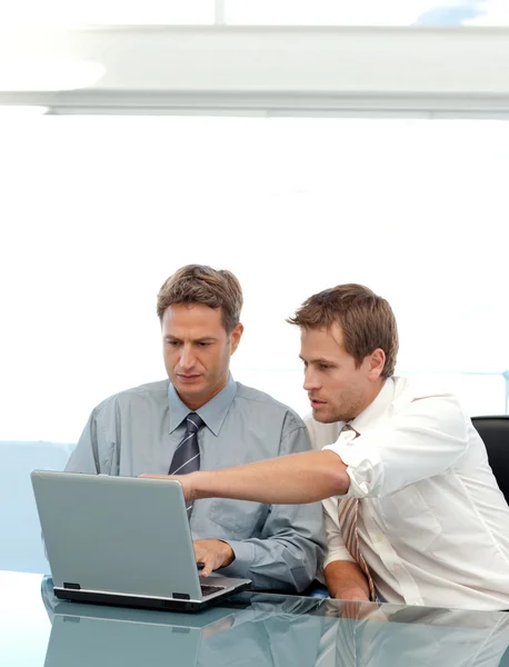 Two partners working together on a laptop sitting at a table — Stock Photo, Image
