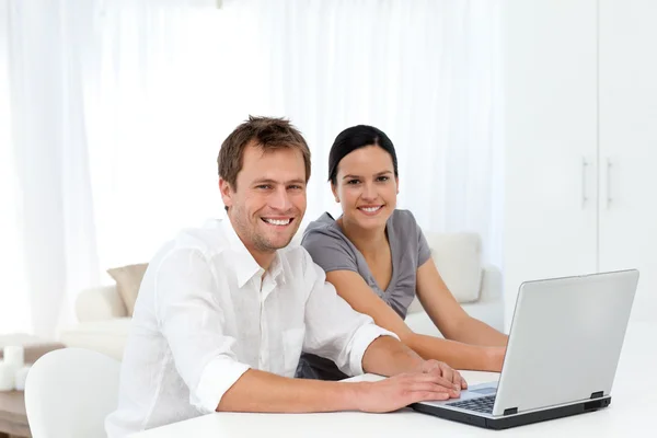 Retrato de um casal trabalhando em seu laptop na sala de estar — Fotografia de Stock