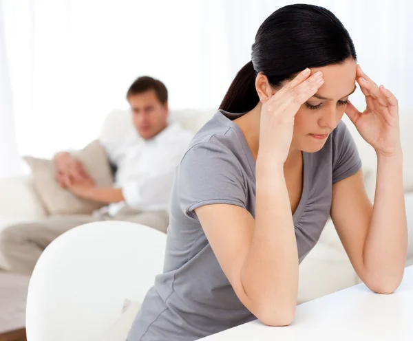 Hombre mirando a su novia teniendo un dolor de cabeza sentado en una pestaña —  Fotos de Stock