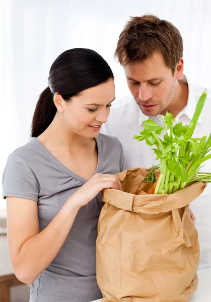 Lovely couple coming back from the market standing in the kitche — Stock Photo, Image