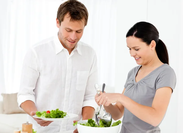 Mulher feliz servindo salada para seu namorado para o almoço — Fotografia de Stock
