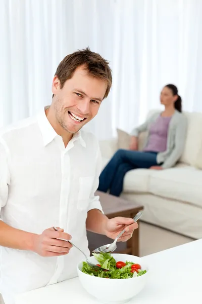 Happy man preparing lunch while his girlfriend relaxing — Stock Photo, Image