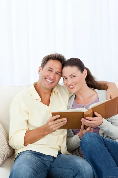 Retrato de una pareja feliz mirando un álbum de fotos —  Fotos de Stock