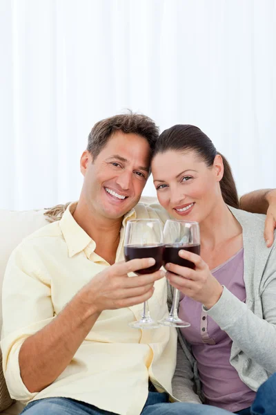 Bella coppia che beve vino rosso sul divano — Foto Stock