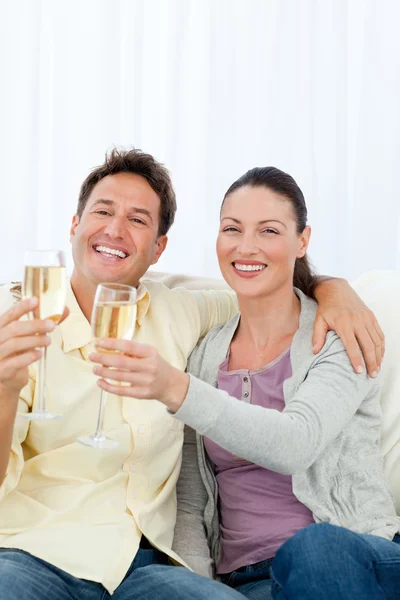 Casal feliz comemorando com flauta de champanhe — Fotografia de Stock