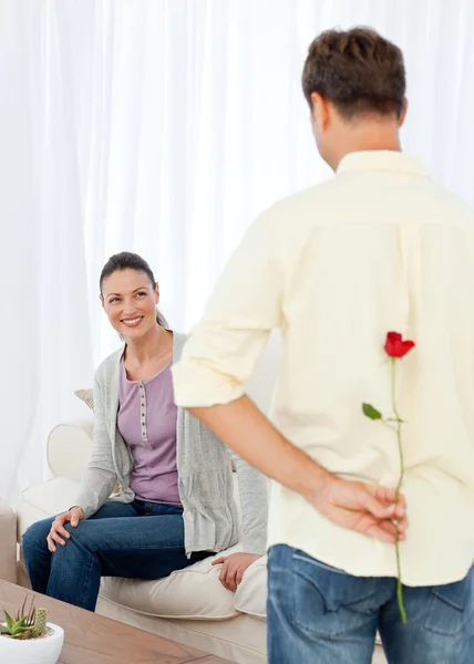 Passionate man hidden a rose behind his back for his grilfriend — Stock Photo, Image