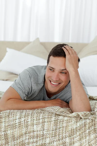 Šťastný muž s úsměvem, leží na posteli — Stock fotografie