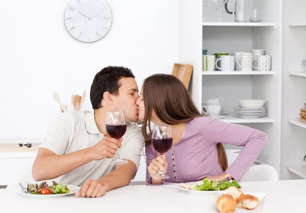 Encantador casal dando um brinde enquanto come uma salada — Fotografia de Stock