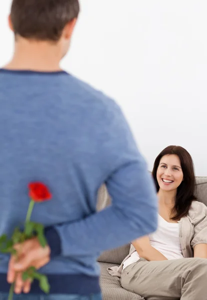 Homme amoureux cachant une fleur derrière son dos pour sa petite amie — Photo