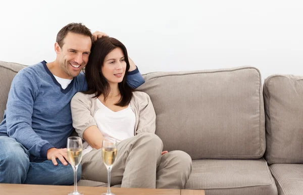 Miłej pary oglądanie telewizji podczas picia szampana — Zdjęcie stockowe