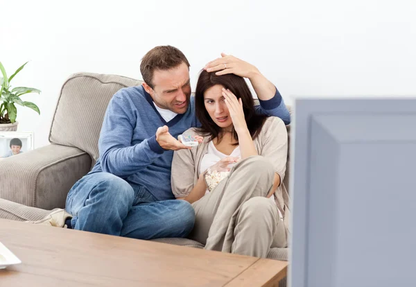 Mulher assustada assistindo a um filme de terror com seu namorado — Fotografia de Stock