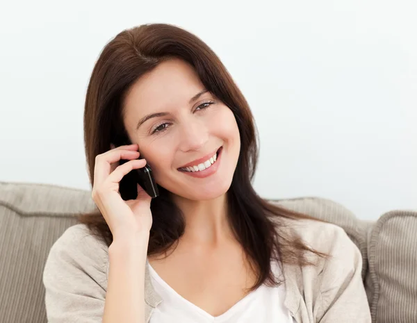 Mujer feliz en el teléfono sentado en el sofá —  Fotos de Stock