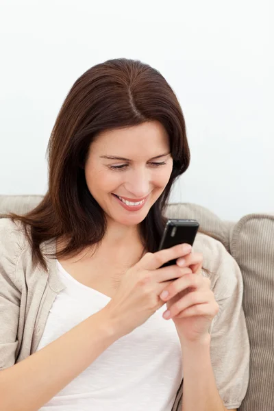 Glückliche Frau sendet eine Nachricht mit ihrem Handy — Stockfoto