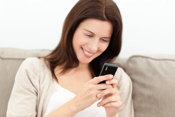Vacker kvinna läser ett meddelande på sin mobiltelefon — Stockfoto