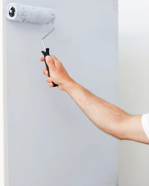 Close up of a man painting a wall in white — Stock Photo, Image