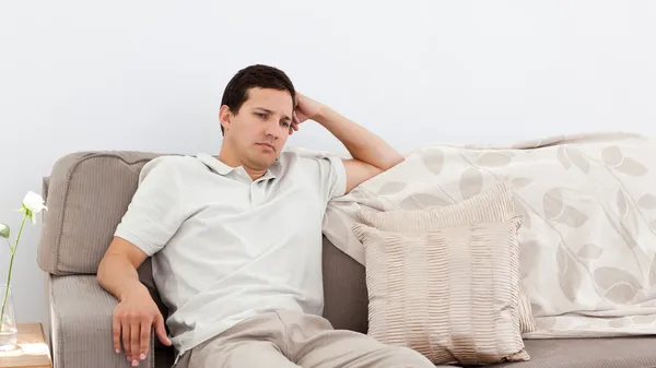 Przygnębiony człowiek myśli na kanapie — Zdjęcie stockowe