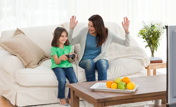 Fröhliche Mutter schaut ihre Tochter bei Videospielen an — Stockfoto