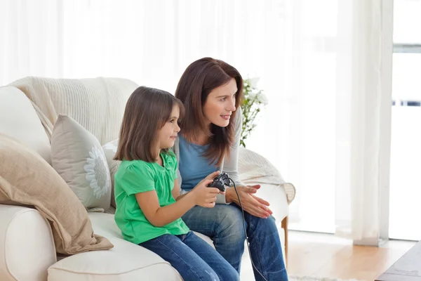 Внимательная мать поощряет свою дочь играть в видеоигры — стоковое фото