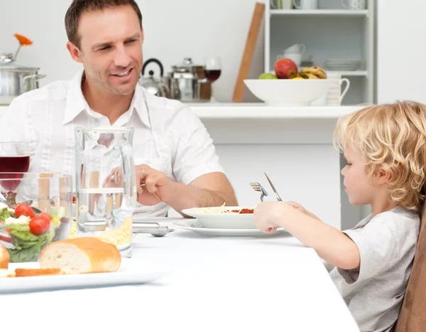 Gelukkig Papa kijken naar zijn zoon eten pasta — Stockfoto