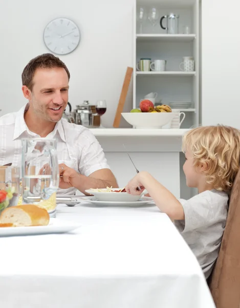 Orgulloso papá hablando con su hijo mientras comen pasta juntos —  Fotos de Stock