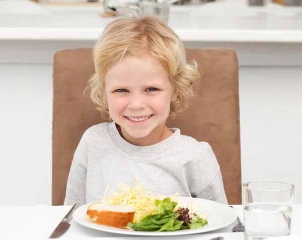 Netter kleiner Junge isst Nudeln und Salat — Stockfoto