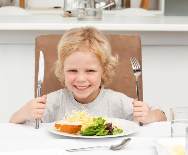 兴奋的男孩抱着叉子吃面食和沙拉 — 图库照片